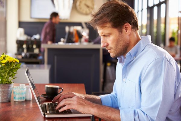 man on laptop using the Coaching Others for Performance Excellence program